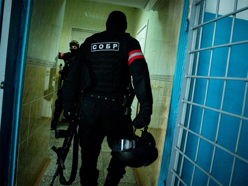 Сотрудники подразделения специального назначения занимают позиции в помещениях на первых этажах здания, в котором укрепились условные террористы