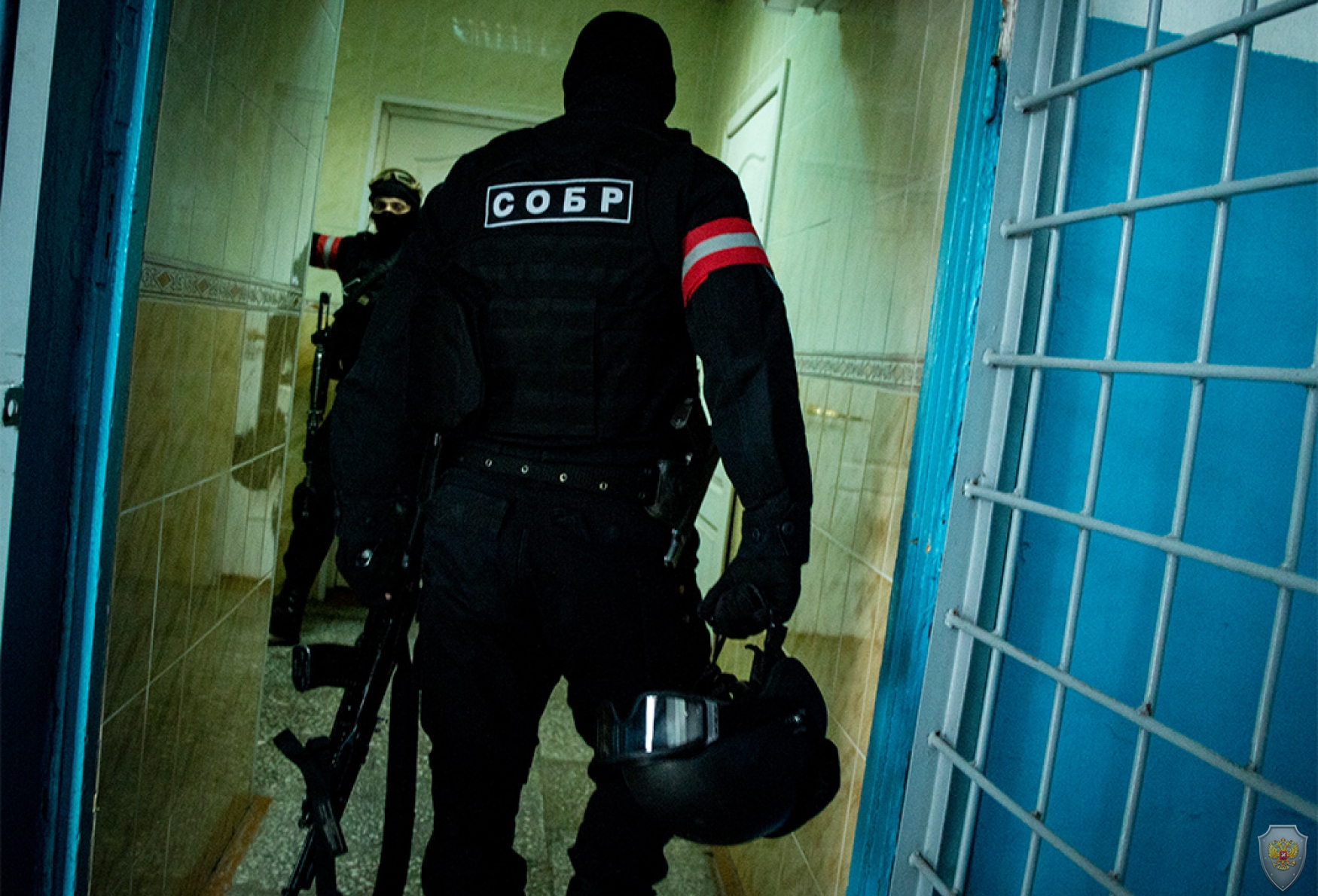 Сотрудники подразделения специального назначения занимают позиции в помещениях на первых этажах здания, в котором укрепились условные террористы